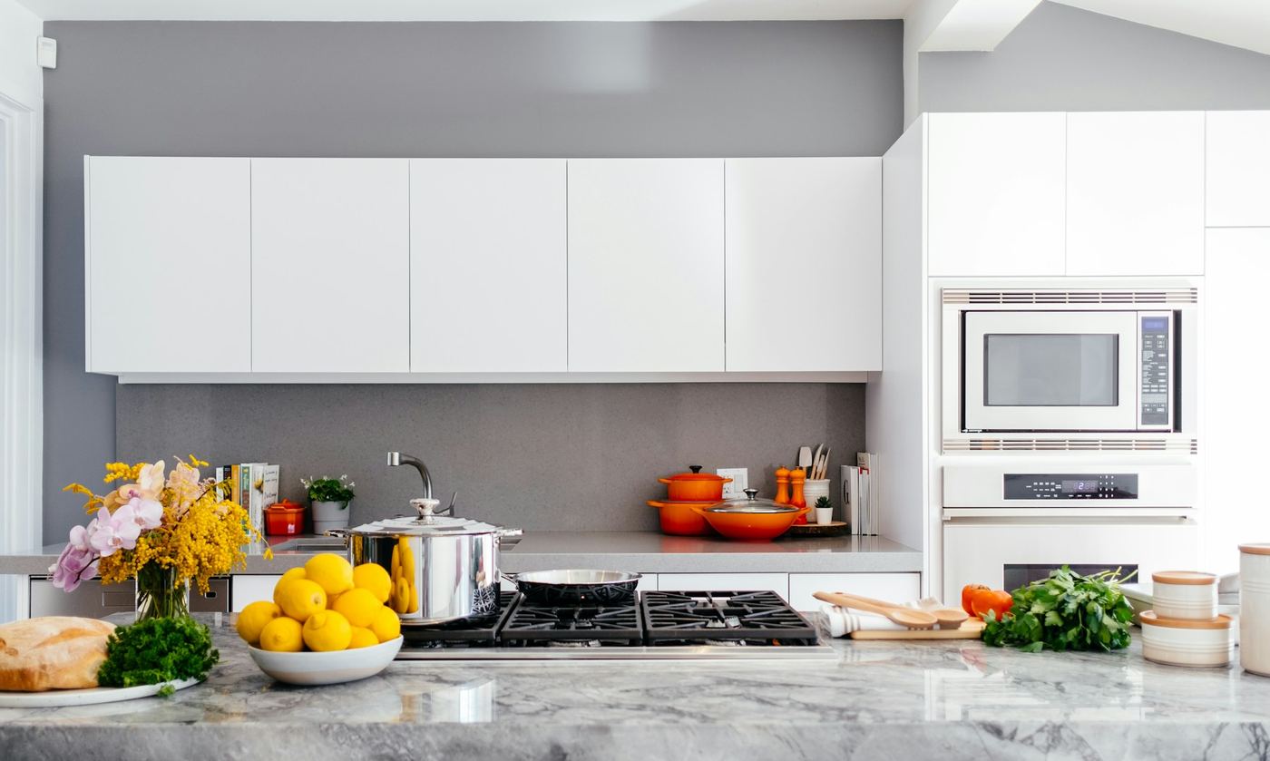 Cucina bianca con piano in pietra e fornelli